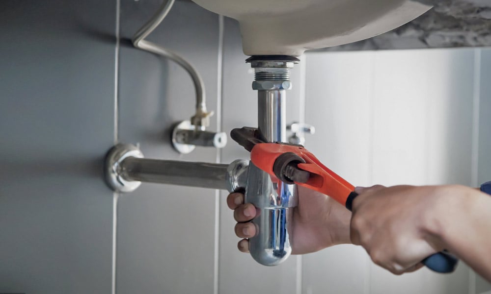Plumbing Components Home Warranty Coverage | Plumber working on pipes