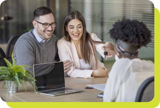 Smiling couple sitting at desk with agent