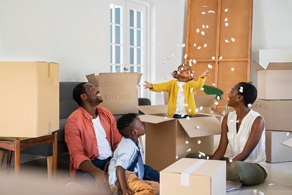 A father, mother, and two children unpacking boxes, having fun