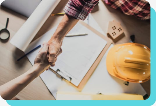 Builders shake hands over construction plans