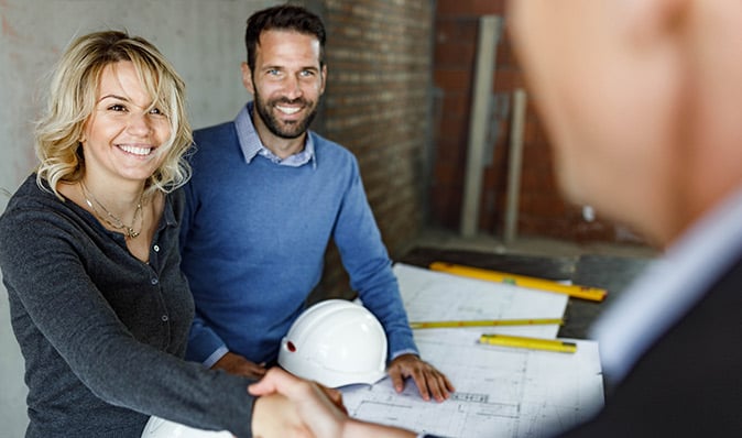 Happy Couple reviewing construction plans
