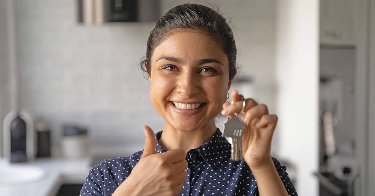 Smiling woman holding up keys