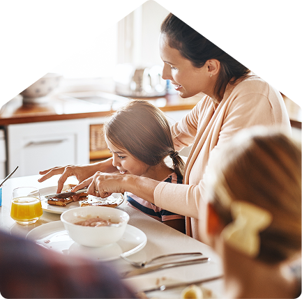 Smiling couple sitting on the floor with a small dog, looking at color samples and flooring options while planning home decor