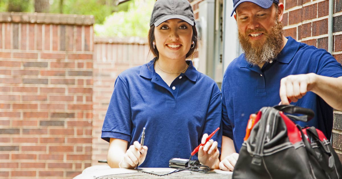 Request Service  Sign in to the Homeowner Portal |A woman and a man, both in blue uniforms and caps, stand outside near an HVAC unit