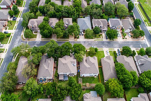 Two rows of homes aerial drone view looking down on rooftop in suburb neighborhood new development street and living area in Austin , Texas