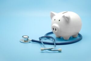 Piggy bank with stethoscope isolated on light blue background.