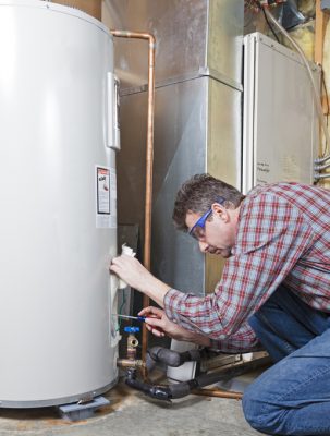A man in a plaid shirt serving a tank water heater