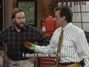 Two repairmen, one in a dark flannel shirt with a beard and one in a striped shirt and tie with no beard, looking at each other. Below them is the caption that says I don't think so, Tim