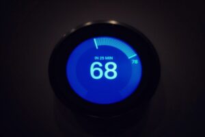 The temperature on modern circle thermostat in black background