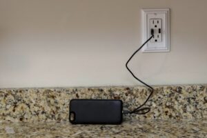 A cellphone charging phone case being charged on a wall outlet