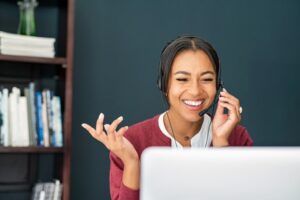 Portrait of smiling Black woman doing video call using laptop. 
