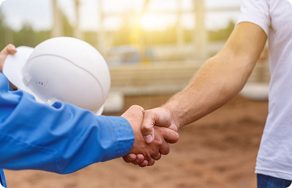 two people shaking hands on a construction site