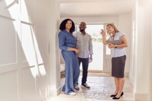 A White female real estate agent showing a Black couple a home