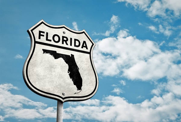A state road sign with the word FLORIDA on top and the shape of Florida on the bottom, signifying a change to Florida law called SB 360