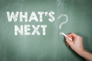 What's next. Text with a question mark on a green chalkboard background.