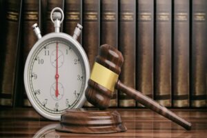 Stopwatch, timer and judge gavel in front of law books background. 3d illustration
