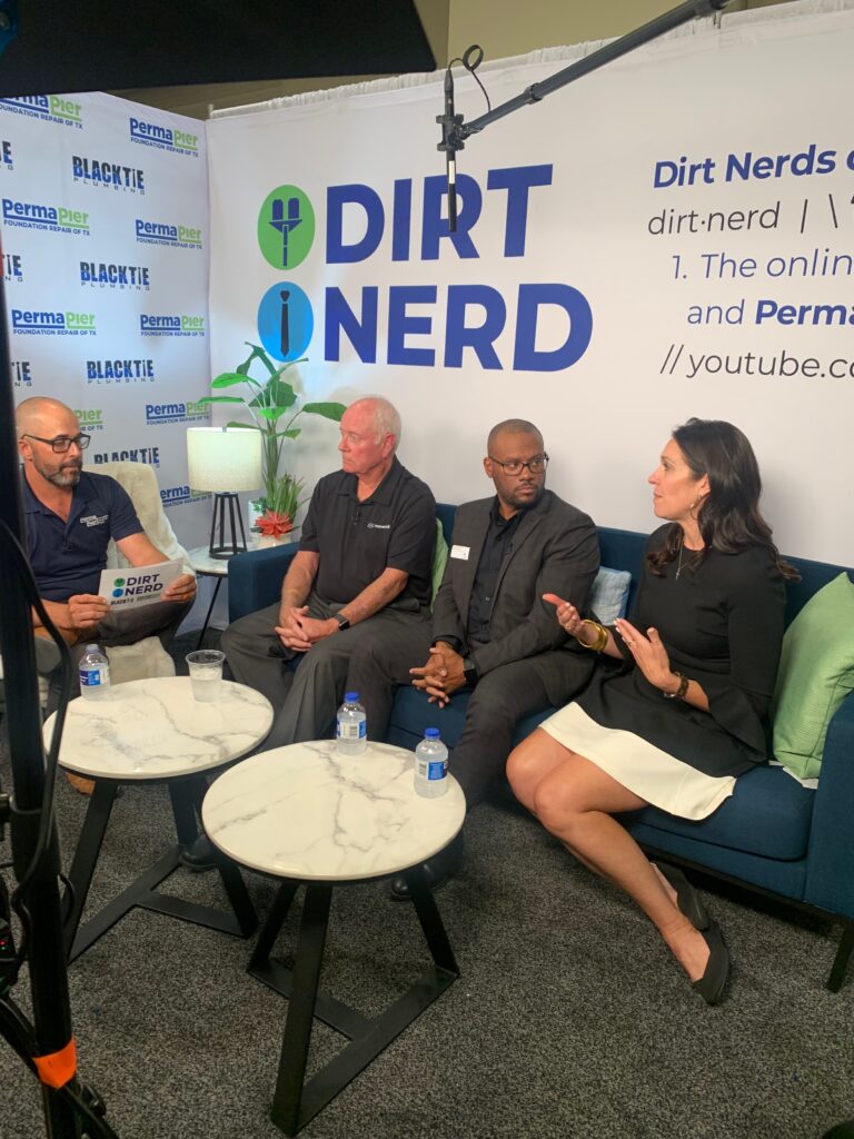three men and a woman sitting on a couch in front of a sign that says DIRT NERD