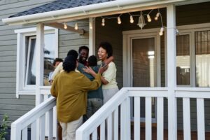 Black Family Embracing on a wraparound porch of a beautiful house