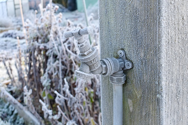 close up of outdoor water tap covered in frost that needs deicing