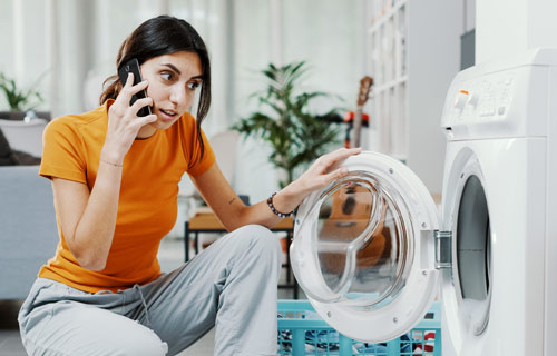 Woman inspecting broken washer